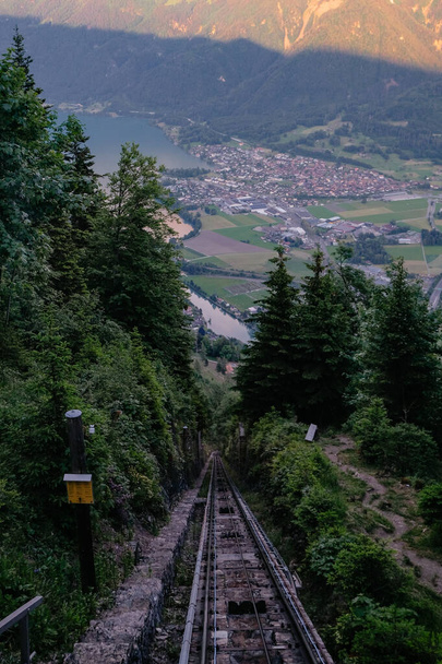 Red Funicular Train driving downhill from Harder Kulm, Top of Interlaken. Funicular drives tourists up and down from popular view point. Transportation, tourism - Swiss Alps, Interlaken, Switzerland - Photo, Image