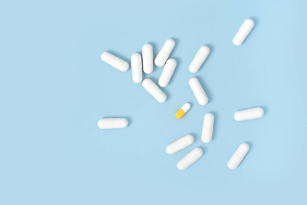 Sparse capsule di pillole bianche su sfondo blu tavolo. Medicina, farmacia e assistenza sanitaria. Ricevuto. Posa piatta. - Foto, immagini