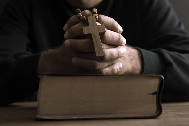man holding cross with Holy Bible on tabl - Foto, imagen