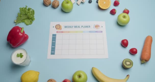 Blanco maaltijd plan en verschillende producten op kleur achtergrond, video met stop motion effect - Video