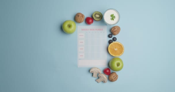 Blank meal plan and different products on color background, video with stop motion effect - Footage, Video