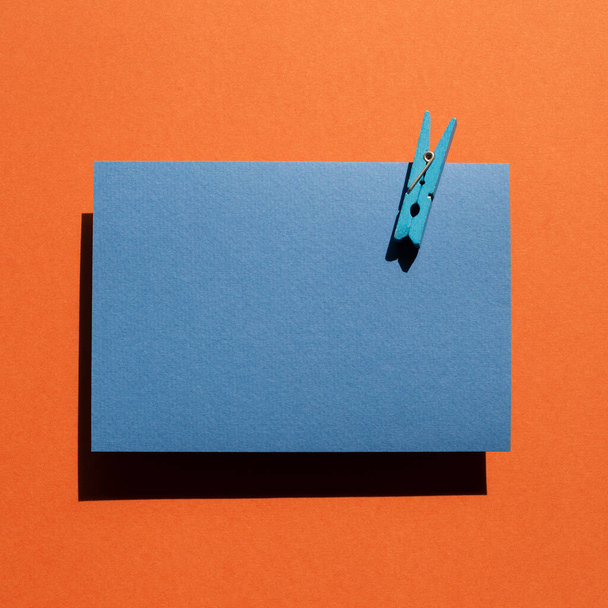Blue memo pad with wooden clip on red background. top view, copy space - Photo, Image