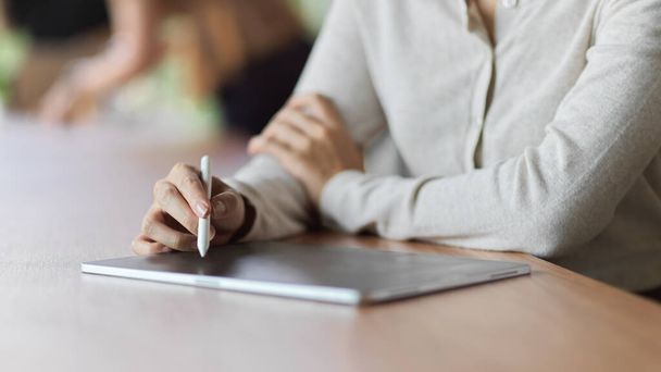Vue rapprochée de la femme utilisant une tablette avec stylet pour prendre des notes lors de la réunion, Femme utilisant une tablette avec stylet concept de stylo - Photo, image