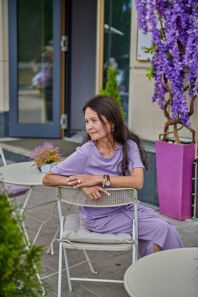 lilac summer cafe and a girl on a chair - Foto, Bild
