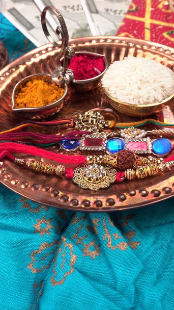 Festival indiano: Raksha Bandhan fundo com um elegante Rakhi, grãos de arroz e Kumkum. Uma pulseira tradicional indiana que é um símbolo de amor entre irmãos e irmãs. - Foto, Imagem