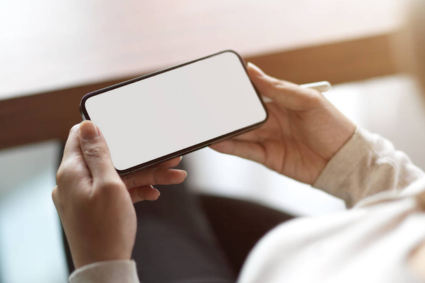 Nahaufnahme des leeren horizontalen Smartphone-Bildschirms, Frau hält Smartphone mit leeren Kopierraum - Foto, Bild