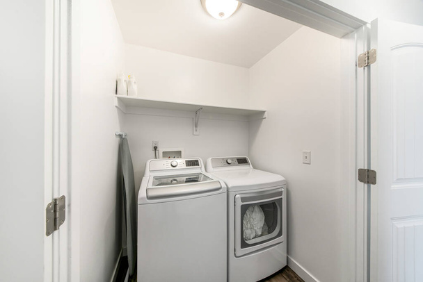 Mała szafa na pranie ze składaną deską do prasowania i podwójnymi drzwiami - Zdjęcie, obraz