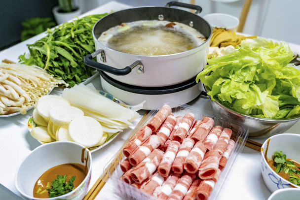 Ένα τραπέζι από νόστιμα και ατμό κινεζική ζεστό κατσαρόλα - Φωτογραφία, εικόνα