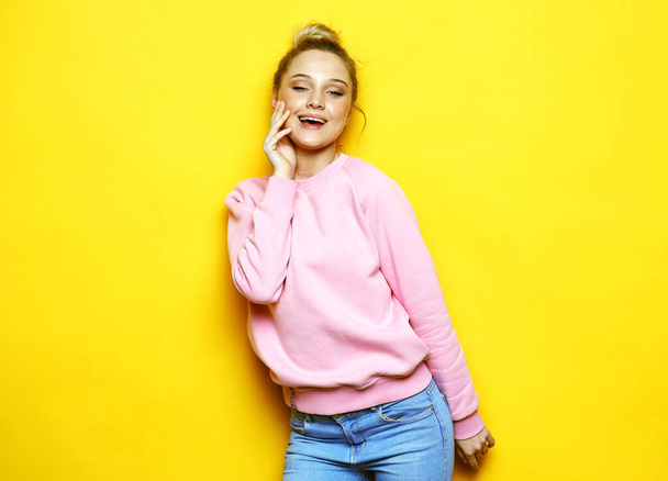 Young and cheerful blonde womanwearing pink shirt smiling and laughing over yellow background - Zdjęcie, obraz