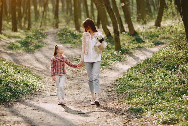 Mother with daughter in a spring forest with dog - Photo, Image