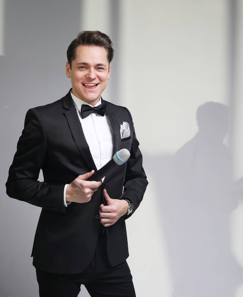 Young Showman presenter with microphone against white background. Showman concept. - Zdjęcie, obraz