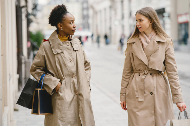 Happy mixed girls walking the street with shopping bags - Valokuva, kuva