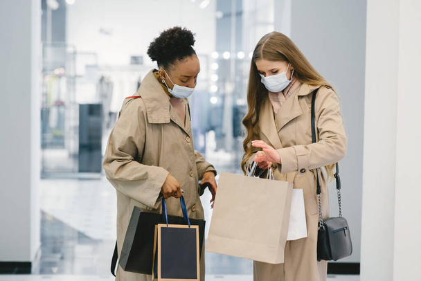 Happy mixed girls walking the store with shopping bags - Valokuva, kuva