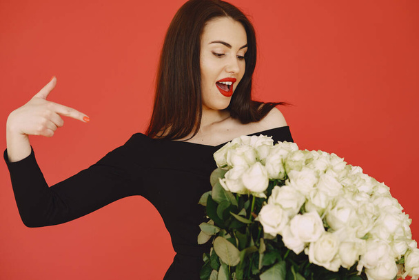 Woman in a black dress with bouquet of roses - Fotoğraf, Görsel