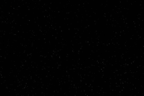 Night sky with brightly shining stars. white snow on black background - Photo, Image