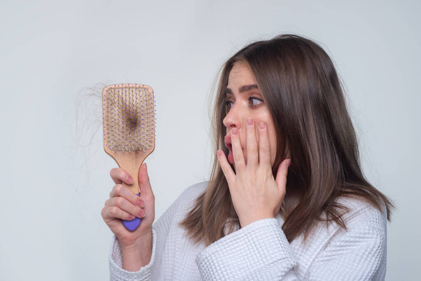 Woman hand holding comb with serious hair loss problem for health care shampoo. - Fotoğraf, Görsel