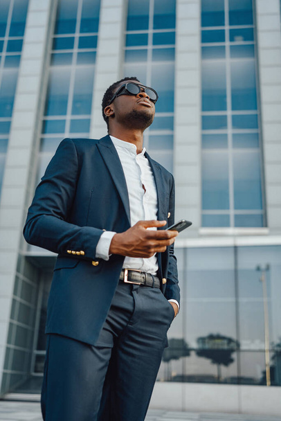 Fashionable businessman of african ethnic holding phone - Photo, Image