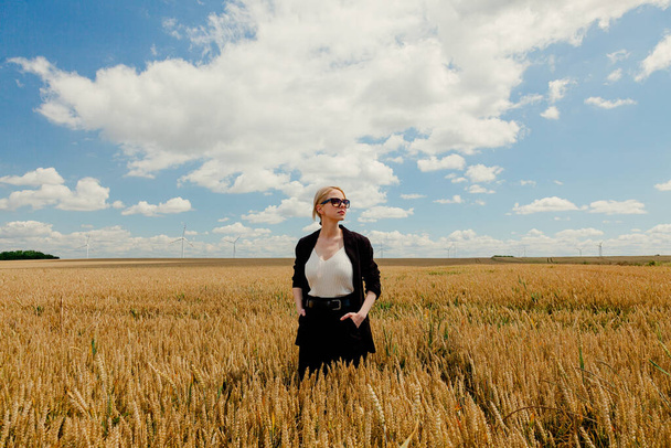 Stylish woman with blond hair posing in formal clothes in wheat field - Photo, Image