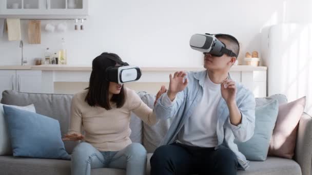 Pareja Milenial China Experimentando la Realidad Virtual Sentada en Casa - Imágenes, Vídeo