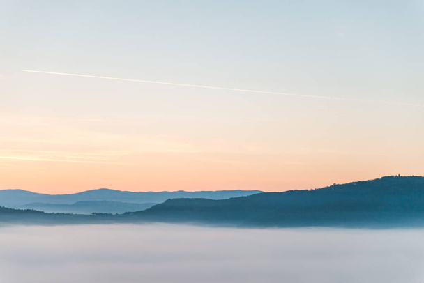 view of sunrise above mountains mist in the bottom landscape - Фото, изображение