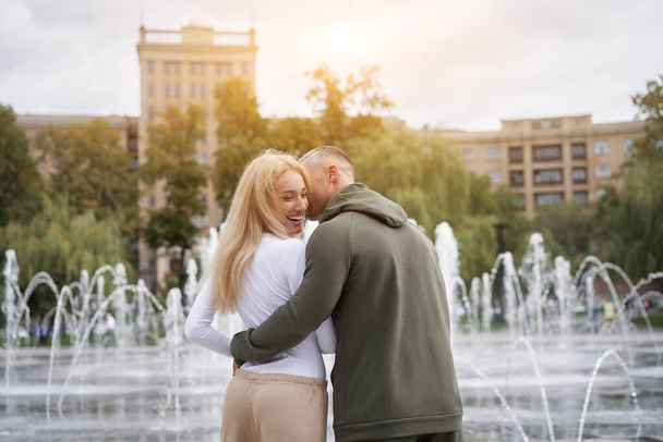 Couple in love walking outdoors park fountain Caucasian man woman walk outside after jogging dressed sport clothes  Healthy livestyle  Rear view - Foto, imagen