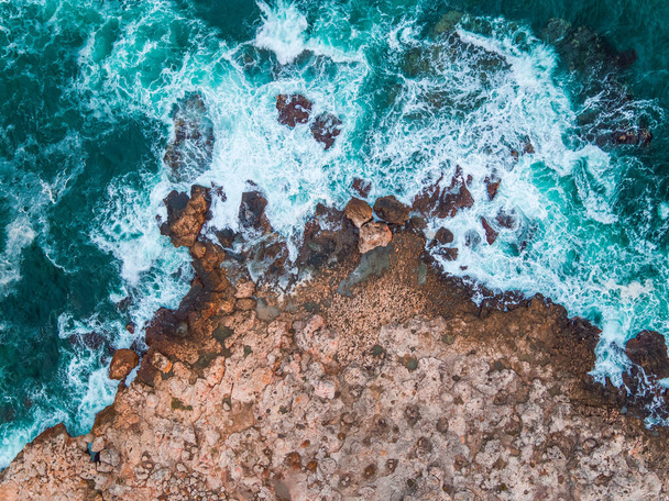 Aerial view of rocky coastline and crashing ocean waves - 写真・画像