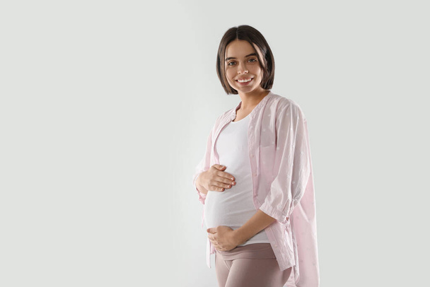 Happy young pregnant woman on white background, space for text - Foto, immagini