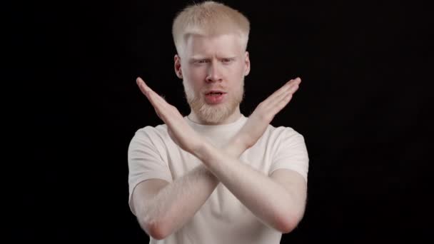 headshot di albino uomo gesturing smettere di rifiutare su sfondo nero - Filmati, video