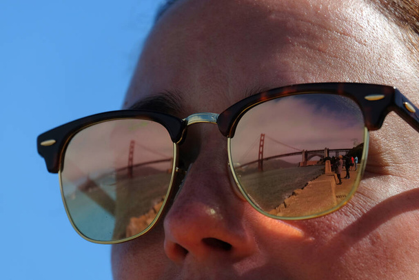 puerta dorada vista a través de los reflejos de las gafas de sol de un joven turista. San Francisco, California, Estados Unidos - Foto, Imagen