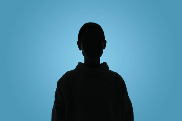Silhouette of anonymous woman on light blue background - Foto, immagini
