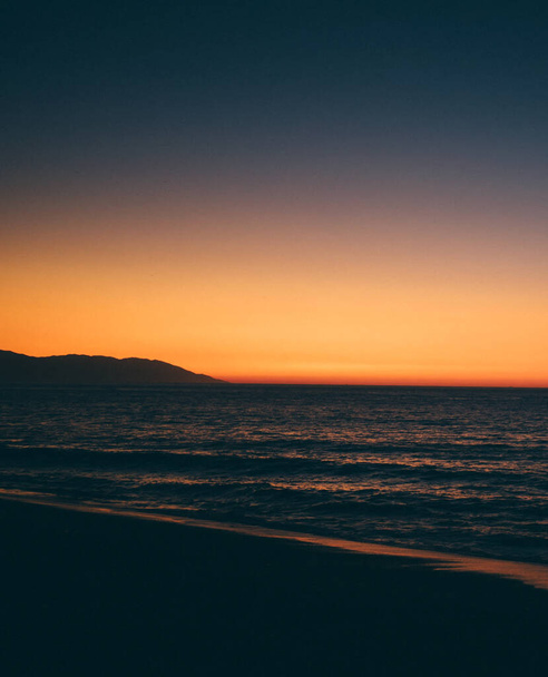 A mesmerizing shot of the sunset sky over the calm sea - Фото, изображение