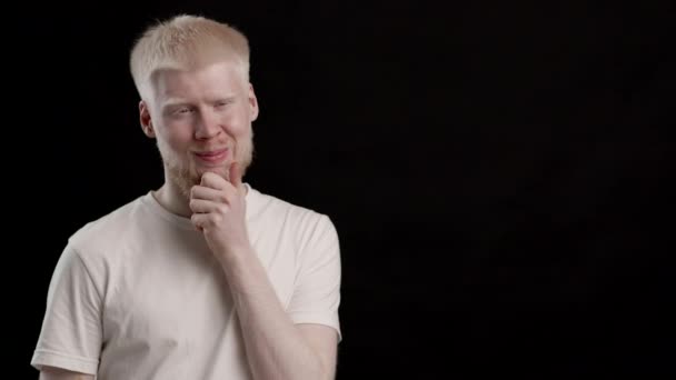 Pozytywny albinos facet myślenie Scratching Broda pozowanie na czarnym tle - Materiał filmowy, wideo
