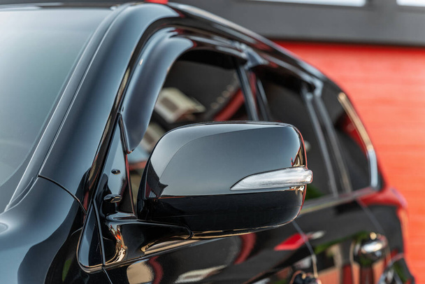 Part of the black modern car. Close-up rearview mirror. Exterior detail. - Foto, immagini