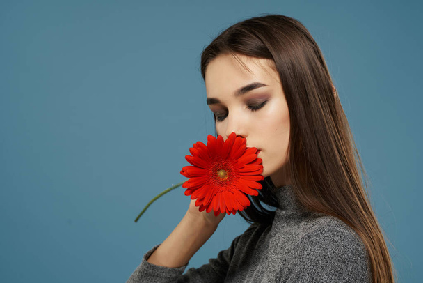 明るいメイクの赤い花のギフトを持つかわいい女性グラマースタジオ - 写真・画像