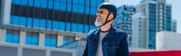 smiling and middle aged man in helmet and sunglasses in city, banner - Fotoğraf, Görsel