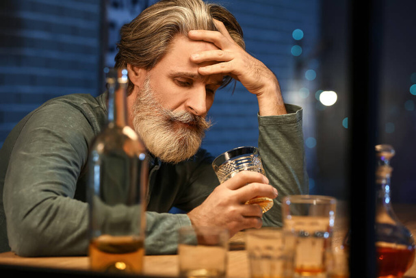 Betrunkener Senior mit Glas Whiskey spät abends zu Hause - Foto, Bild