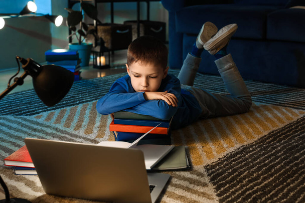 Little boy doing homework at home late in evening - 写真・画像