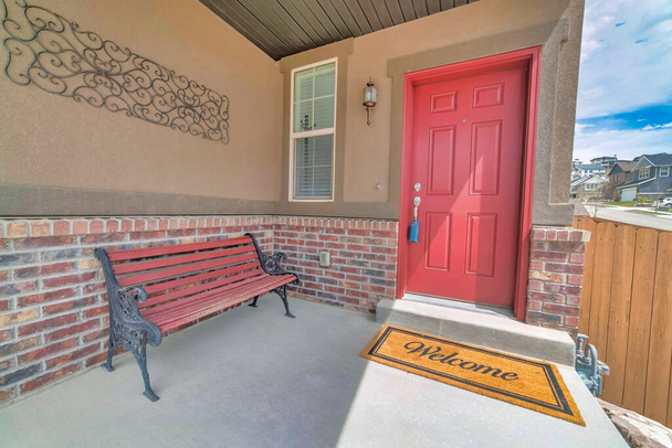 Otthoni homlokzat zárható a piros bejárati ajtón és pad a nyitott verandán - Fotó, kép