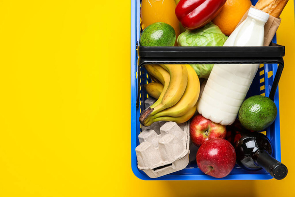 Ostoskori ruoan kanssa värillisellä taustalla - Valokuva, kuva
