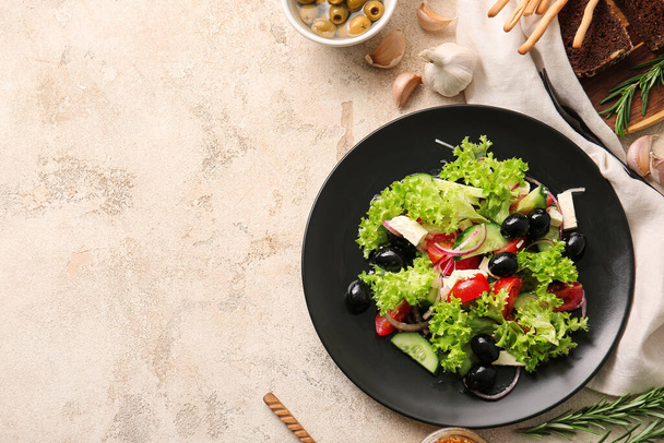 Teller mit leckerem griechischen Salat auf Grunge-Hintergrund - Foto, Bild
