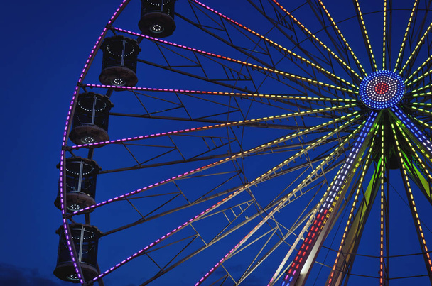 Высокое колесо обозрения на фоне тёмного ночного неба во время нашего летнего отдыха на Адриатическом море. Поездка в парк развлечений. Концепция праздников. - Фото, изображение