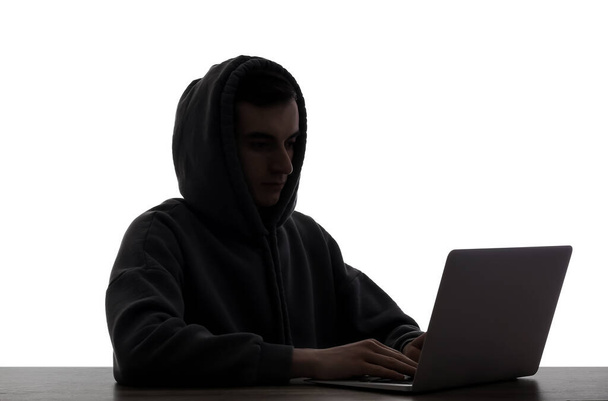 Silueta de hacker con portátil en la mesa sobre fondo blanco - Foto, imagen