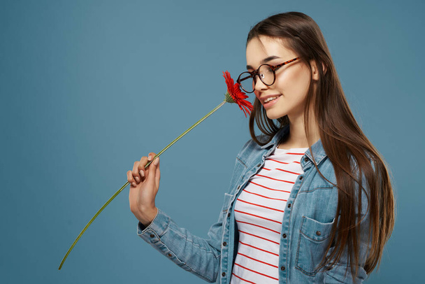 mujer usando gafas rojo flor cerca de cara estudio de moda - Foto, imagen