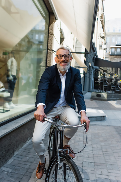happy mature man listening music in earphones and riding bicycle  - Fotó, kép