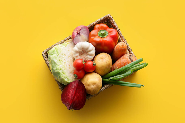 Wicker basket with ingredients for preparing borscht on color background - 写真・画像