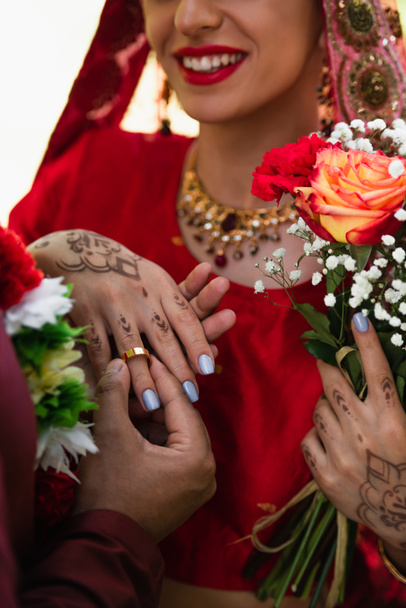 vista parcial del hombre indio feliz con anillo de boda en el dedo de la novia  - Foto, Imagen