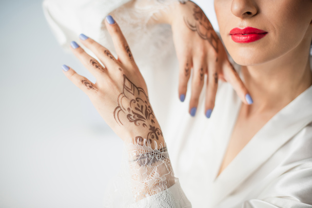 cropped view of young indian bride with mehndi on hands isolated on white - Foto, Imagen