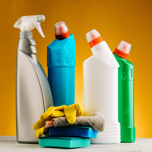 Bottles of detergent and cleaning products on a yellow background - Foto, immagini