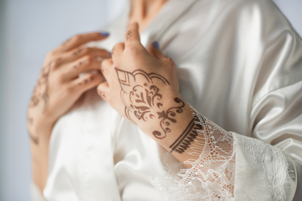 обрезанный вид молодой индийской женщины с mehndi на руках изолированы на белом - Фото, изображение