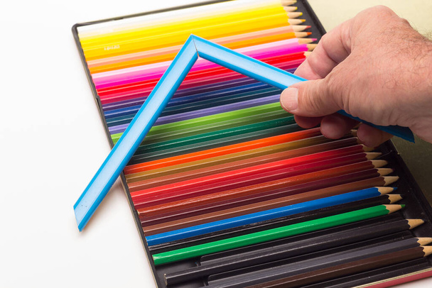 Main, doigts et gamme de couleurs ; crayons de couleur, gamme complète ; angles de couleur tenus par la main adulte - Photo, image